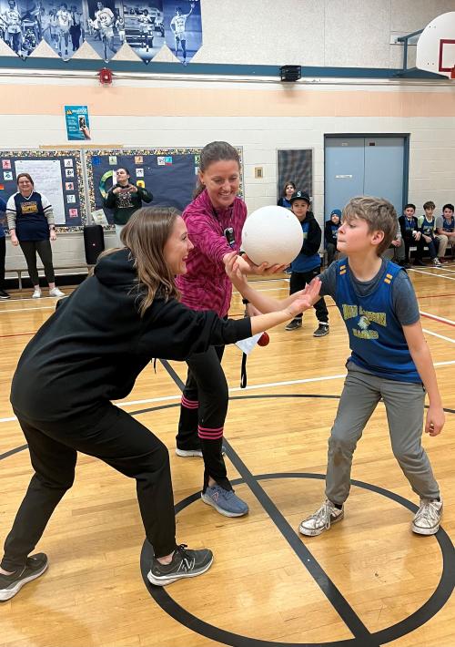 Picture of a teacher and student facing off for a handball game. 