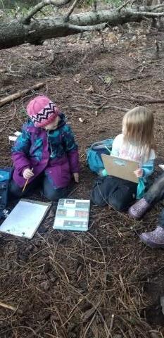 Two students learning outside in the forest