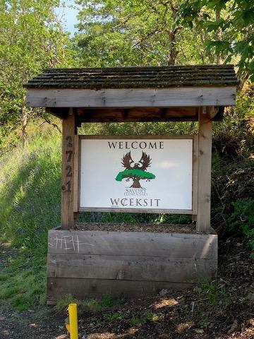 A welcome sign surrounded by greenery