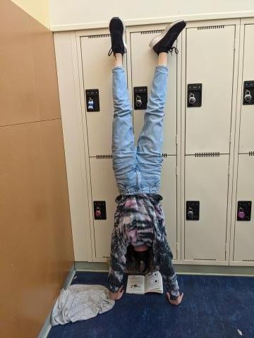 Student reading while in a handstand. Focussed reading time is important, but maybe not while doing a handstand.