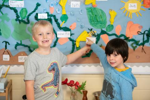 Two students in front of a bulletin board